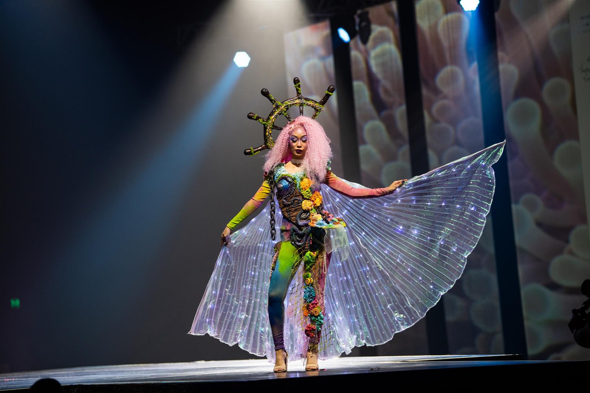 A female model in a colourful costume performing on stage.