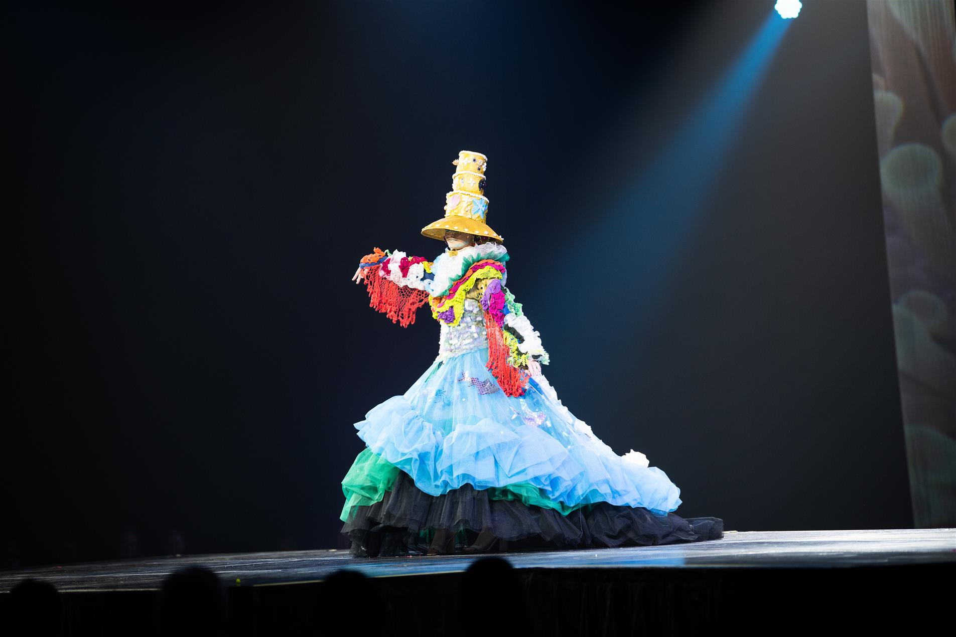 A woman in a colourful dress performing on stage.