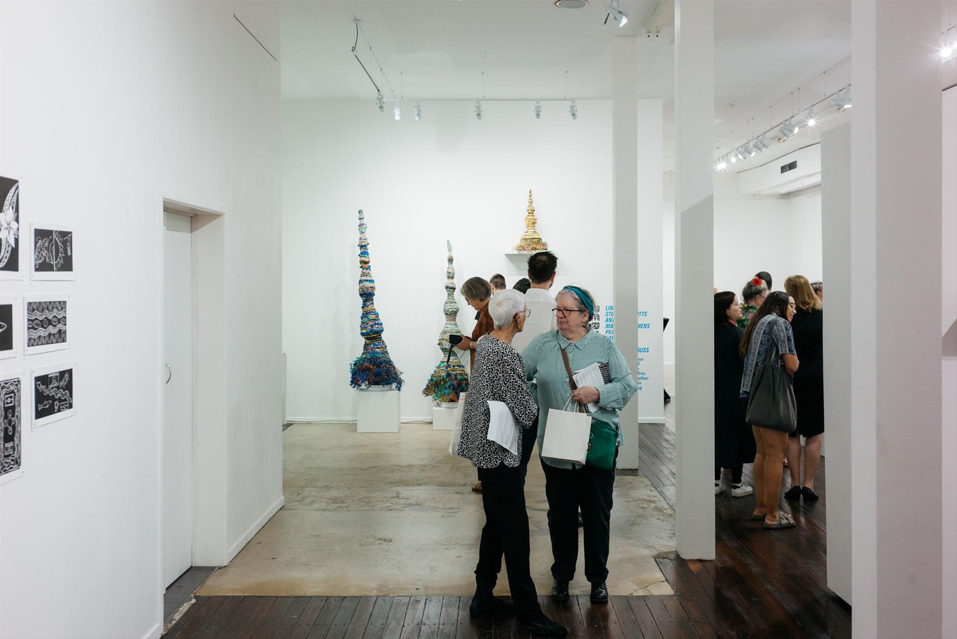 A crowd of people standing in a gallery.