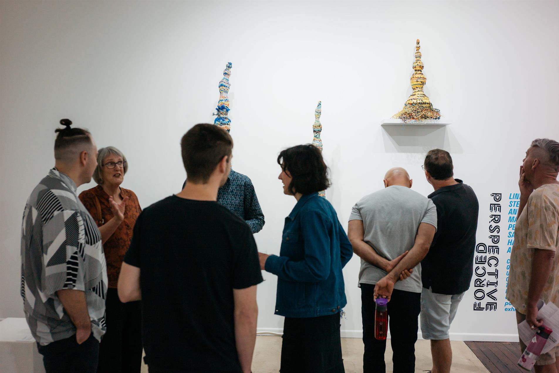 A group of people in a gallery.