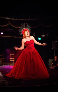 Woman in red dress performing on stage.