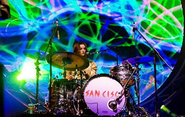 A female artist playing the drums.