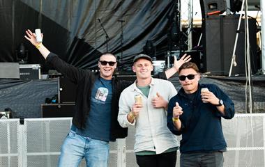 Three males at a music festival.